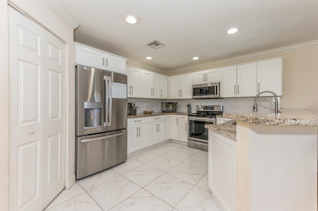 kitchen with light stone countertops, white cabinetry, stainless steel appliances, kitchen peninsula, and crown molding