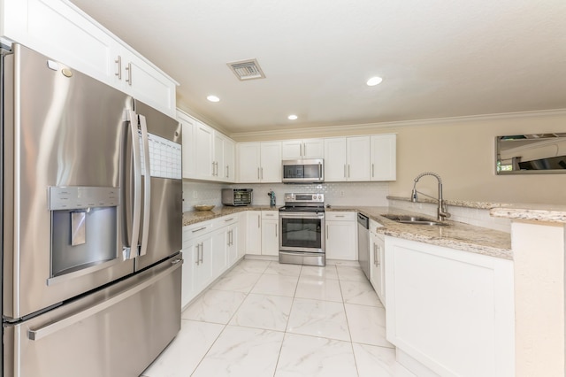 kitchen with light stone countertops, appliances with stainless steel finishes, crown molding, sink, and white cabinets