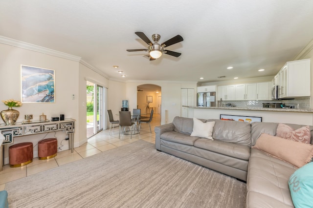 tiled living room featuring ceiling fan and ornamental molding