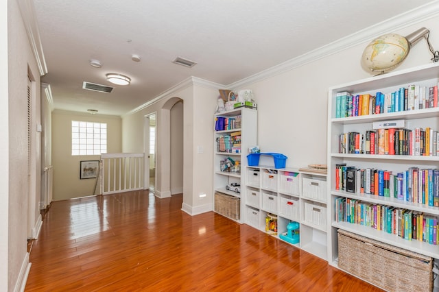 interior space featuring wood-type flooring and crown molding