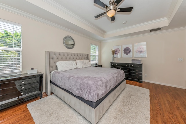 bedroom with multiple windows, ceiling fan, hardwood / wood-style floors, and ornamental molding