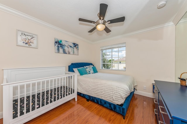 bedroom featuring hardwood / wood-style floors, ceiling fan, and crown molding