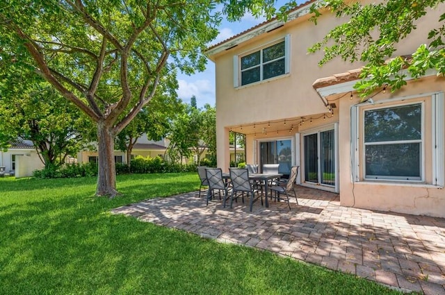 back of property featuring a lawn and a patio area