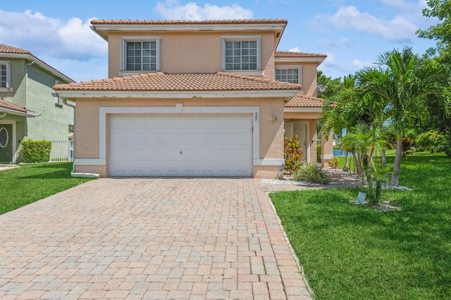 mediterranean / spanish house with a garage and a front lawn