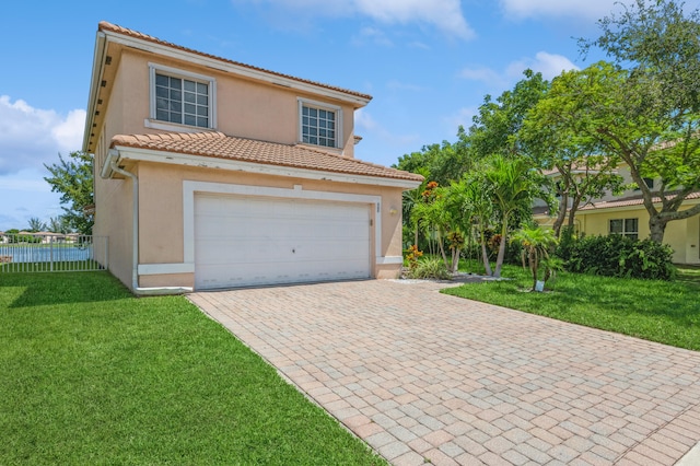 mediterranean / spanish-style house featuring a garage and a front yard