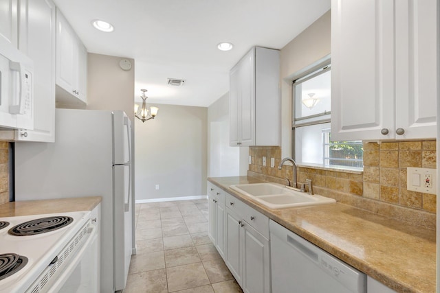 kitchen featuring white appliances, a chandelier, backsplash, white cabinetry, and sink