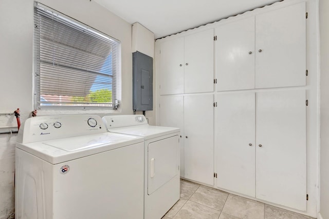 laundry room with electric panel, washer and dryer, cabinets, and light tile patterned floors