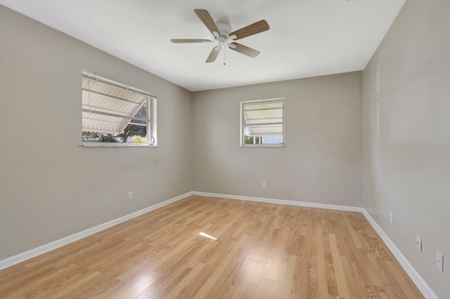 empty room with a healthy amount of sunlight, ceiling fan, and light hardwood / wood-style flooring