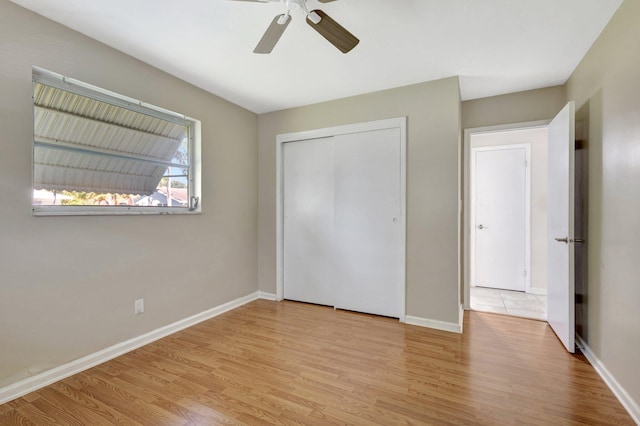 unfurnished bedroom with ceiling fan, light hardwood / wood-style floors, and a closet