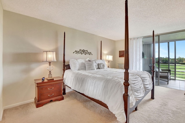 carpeted bedroom with a textured ceiling, access to outside, and floor to ceiling windows