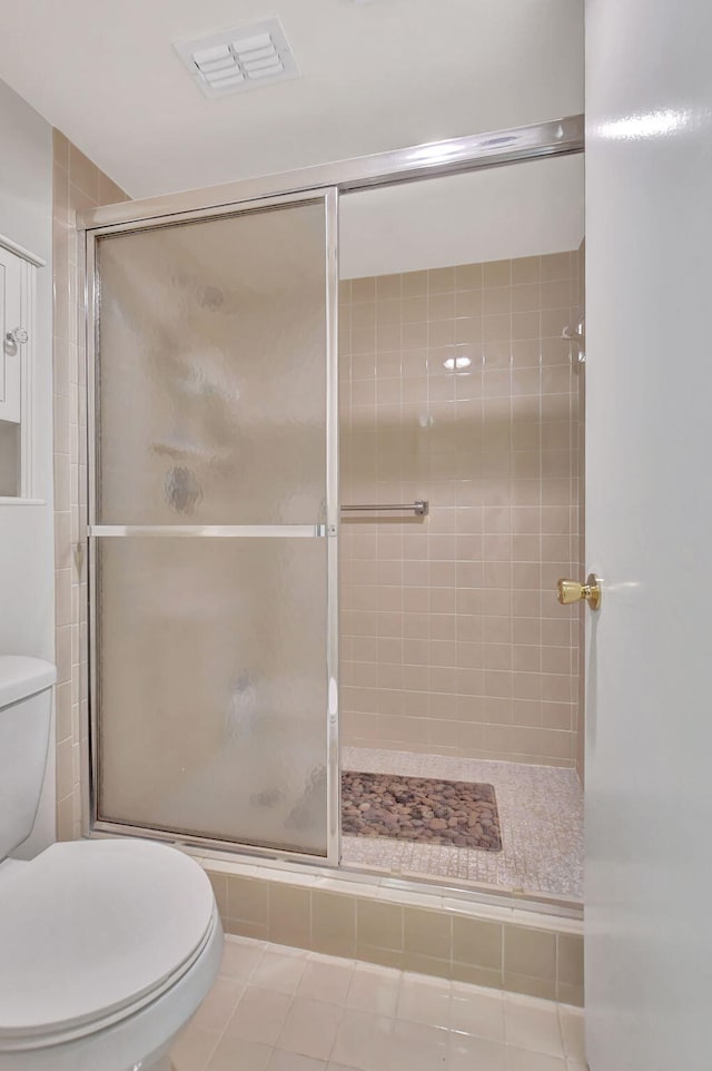 bathroom with walk in shower, tile patterned flooring, and toilet