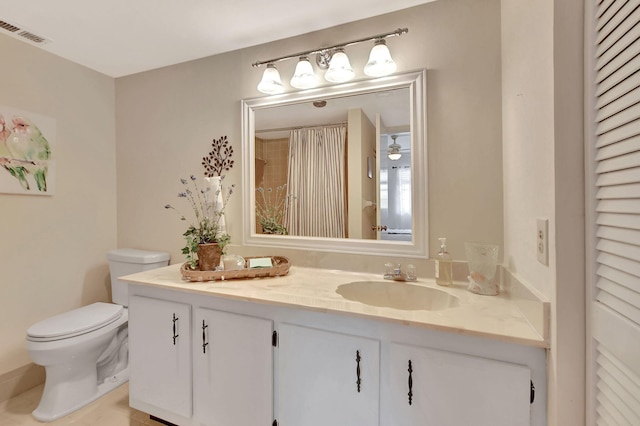 bathroom featuring tile patterned flooring, ceiling fan, vanity, and toilet