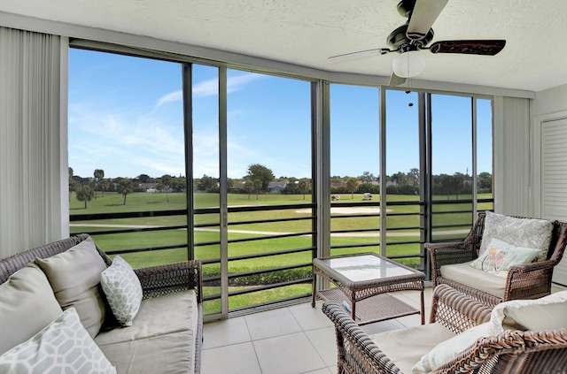 sunroom featuring ceiling fan and plenty of natural light