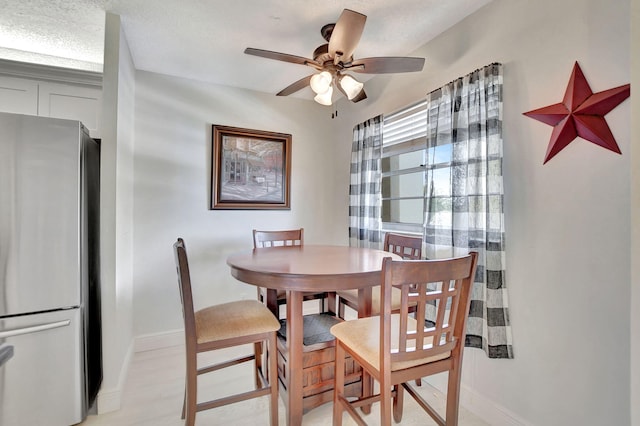 dining area featuring a textured ceiling, ceiling fan, and light hardwood / wood-style flooring