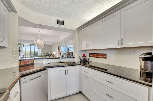 kitchen featuring tasteful backsplash, dishwasher, sink, and a notable chandelier