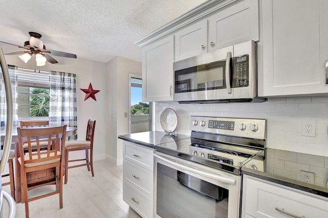 kitchen featuring appliances with stainless steel finishes, tasteful backsplash, light hardwood / wood-style flooring, and a wealth of natural light