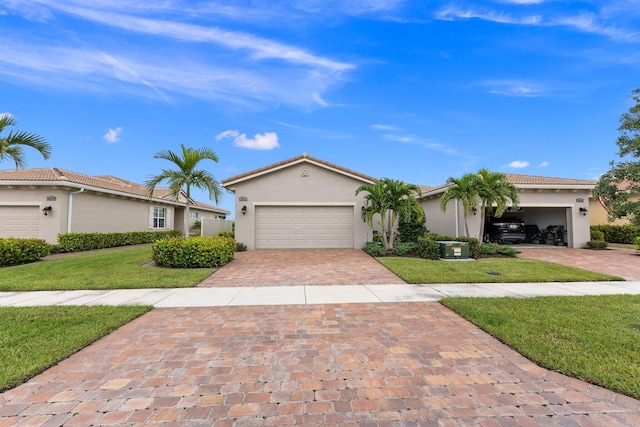 view of front facade featuring a tile roof, a front yard, stucco siding, decorative driveway, and an attached garage