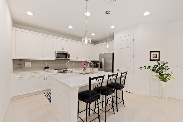 kitchen with decorative backsplash, white cabinetry, sink, and appliances with stainless steel finishes