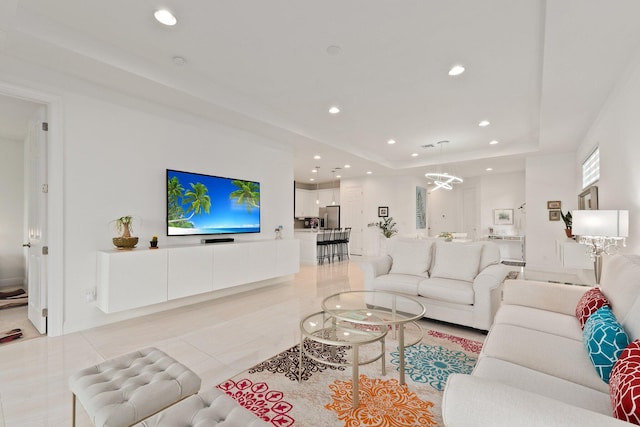 tiled living room featuring a notable chandelier