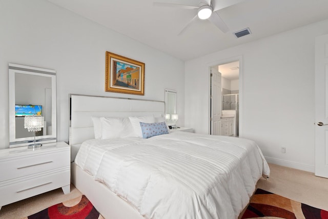 bedroom featuring connected bathroom, ceiling fan, and light colored carpet