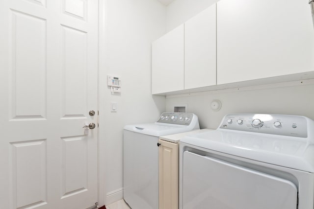 washroom with washer and dryer and cabinets