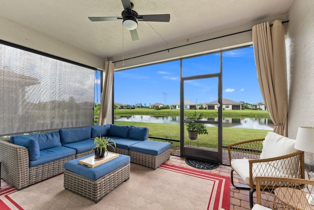 sunroom featuring plenty of natural light, ceiling fan, and a water view