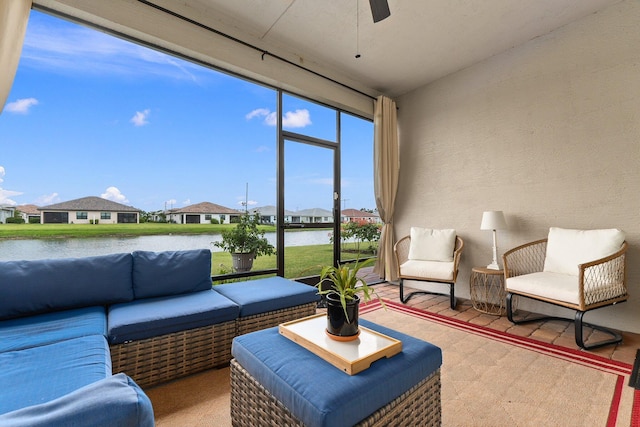 sunroom / solarium with ceiling fan and a water view