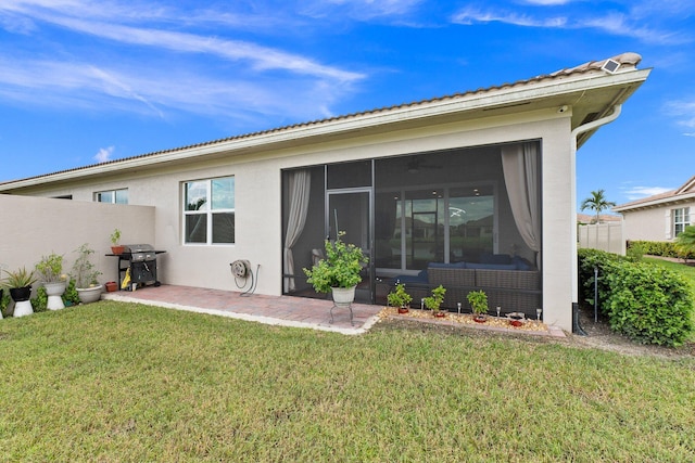 back of property with a sunroom and a yard