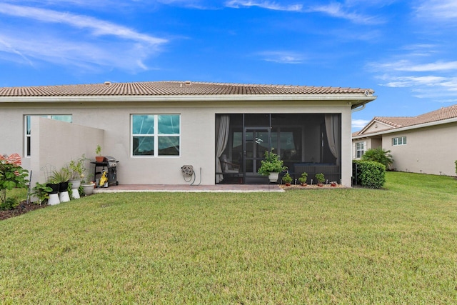 rear view of property featuring a sunroom and a lawn