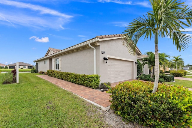 view of home's exterior featuring a garage and a lawn