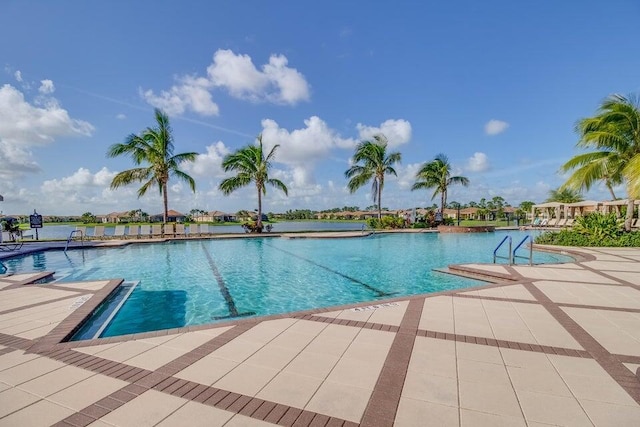 view of pool featuring a patio and a water view