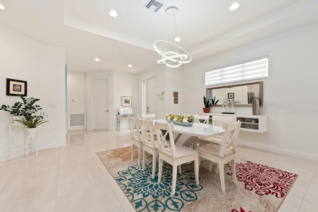 tiled dining space with a tray ceiling and a chandelier