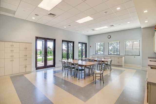 dining room with a paneled ceiling and french doors