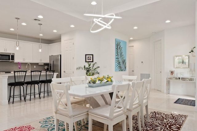 dining space featuring light tile patterned floors and sink