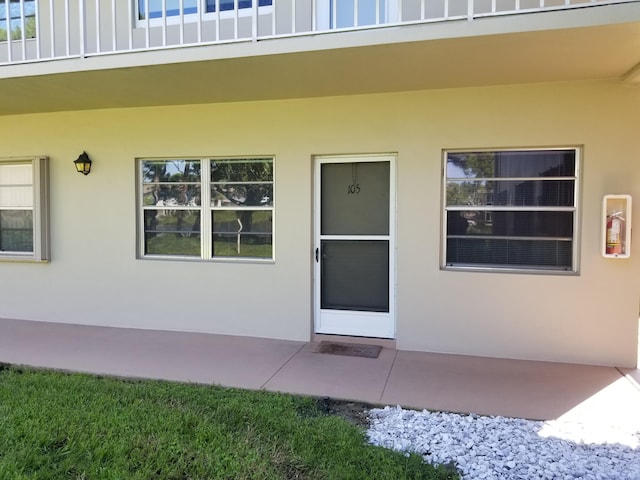 view of exterior entry featuring a balcony