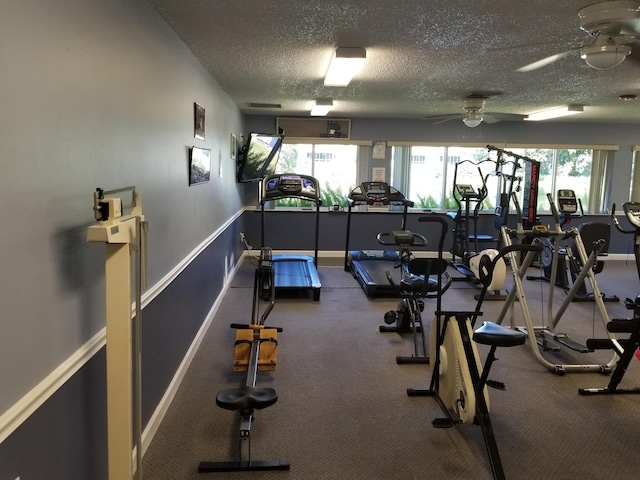 gym with a textured ceiling, a healthy amount of sunlight, carpet flooring, and ceiling fan