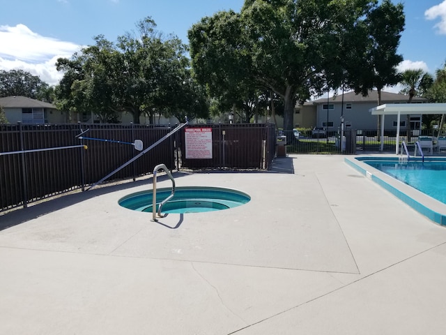 view of swimming pool with a hot tub and a patio area