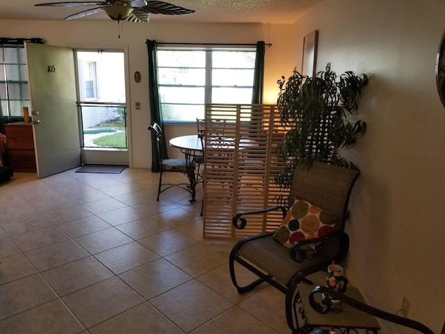 sitting room with ceiling fan, light tile patterned flooring, and a textured ceiling