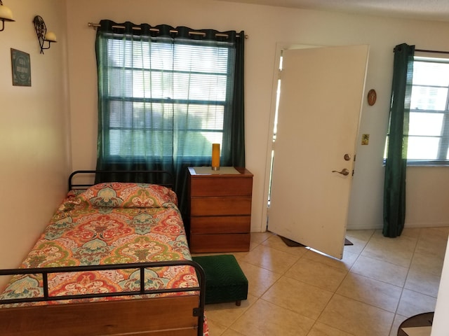 bedroom with multiple windows and light tile patterned floors