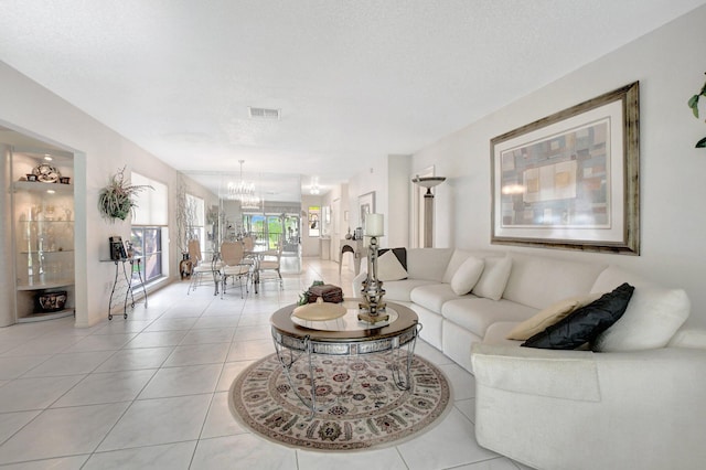 tiled living room with a chandelier and a textured ceiling