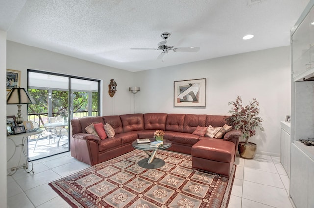 living room with a textured ceiling, light tile patterned floors, and ceiling fan