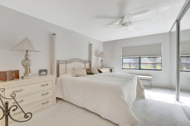 carpeted bedroom with ceiling fan and a textured ceiling