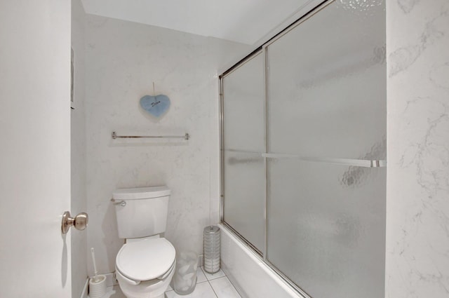 bathroom featuring shower / bath combination with glass door, tile patterned flooring, and toilet