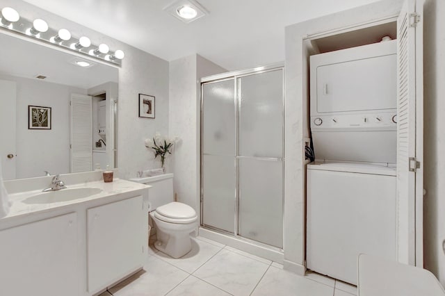 bathroom featuring stacked washer and clothes dryer, vanity, a shower with shower door, and toilet