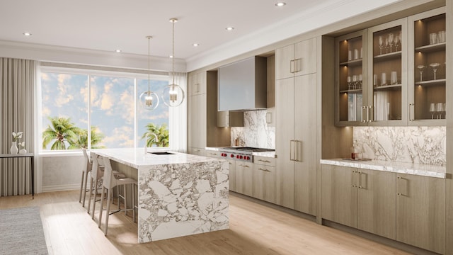 1011 US Highway 1 Unit A202, Juno Beach, FL 33408 - kitchen with stainless steel gas cooktop, modern cabinets, light wood-style floors, a center island with sink, and ornamental molding