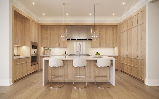 kitchen featuring light brown cabinetry, pendant lighting, light hardwood / wood-style flooring, and wall chimney range hood