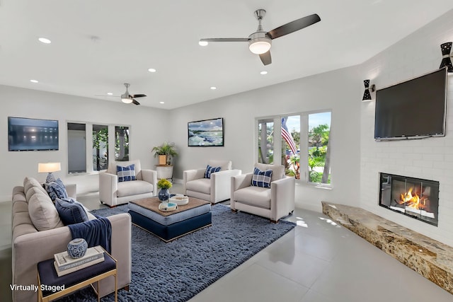 living room with a brick fireplace and ceiling fan