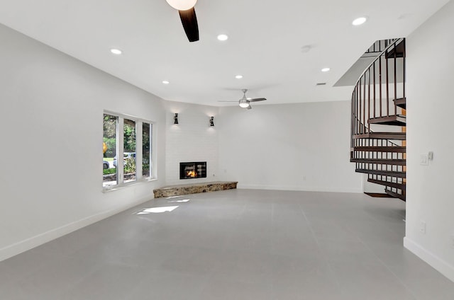 unfurnished living room with a fireplace and ceiling fan