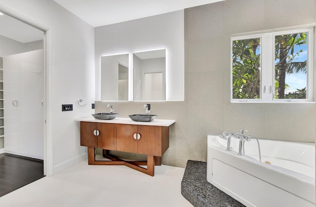 bathroom with a washtub and vanity