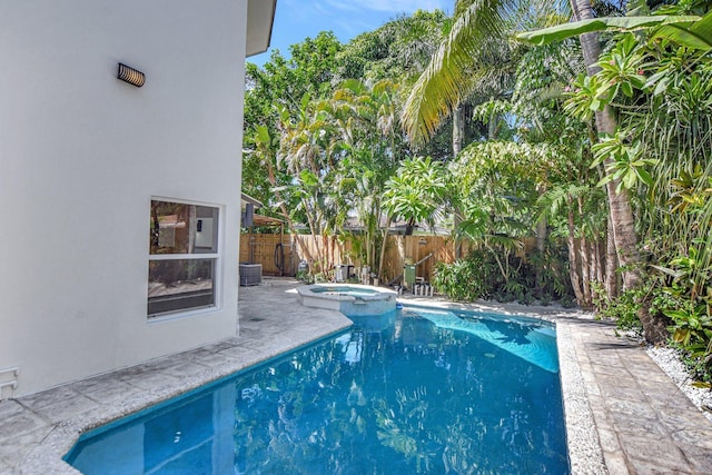 view of swimming pool featuring central AC and an in ground hot tub